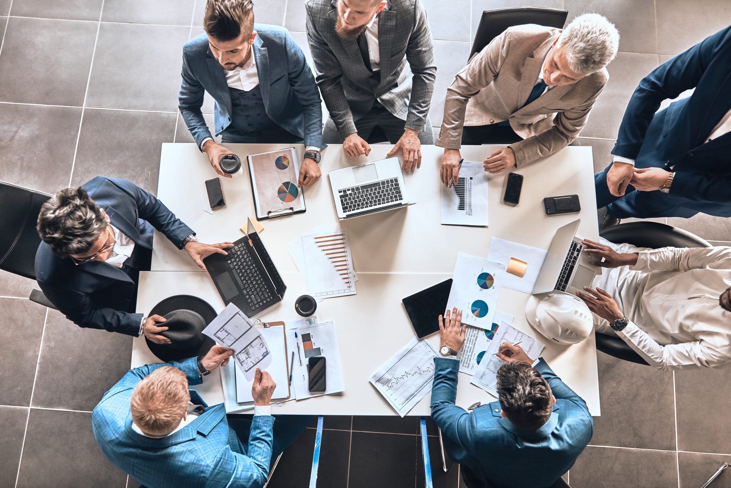 Un gruppo di lavoratori seduti intorno a un tavolo in ufficio, intenti a redigere un business plan